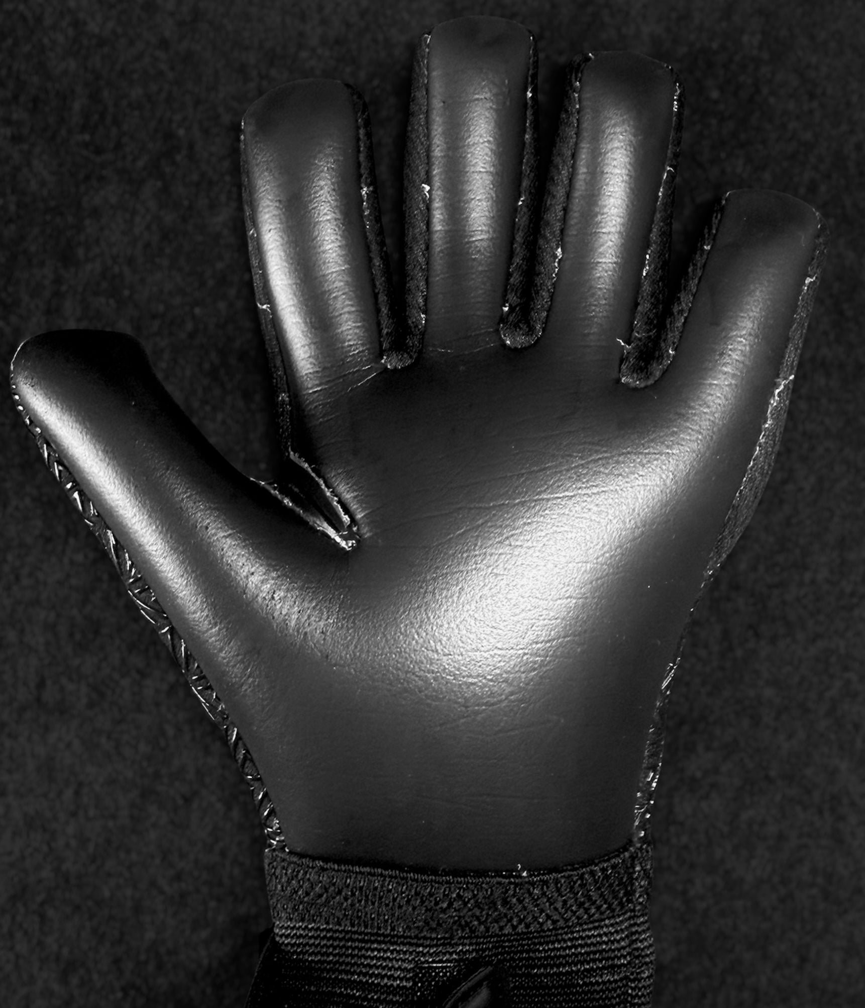 Foundation 01 Goalkeeper Gloves, black, palm side up, against a black background