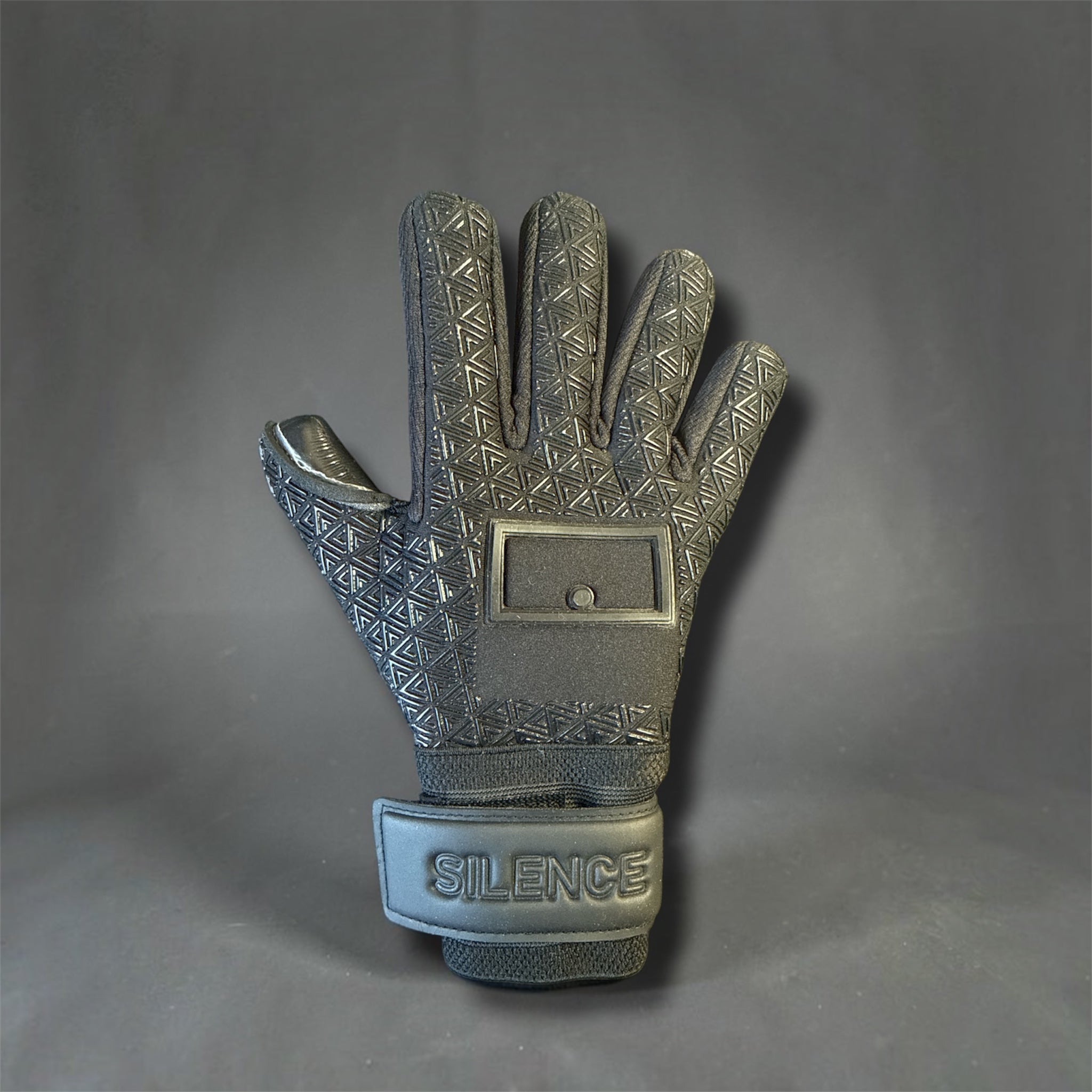 Black goalkeeper glove with a textured pattern and a wrist strap that says SILENCE